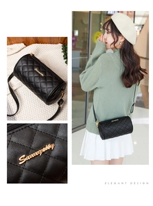 Close-up of black quilted cylinder crossbody bag with golden Sunaycity logo and hardware