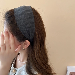 Detail eines dunkelgrauen gerippten Stoffstirnbands am Modell für einen schicken Look