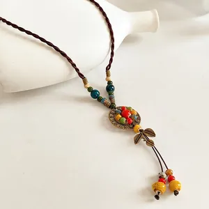 Bohemian ceramic beaded necklace with leaf pendants and bronze accents on white background