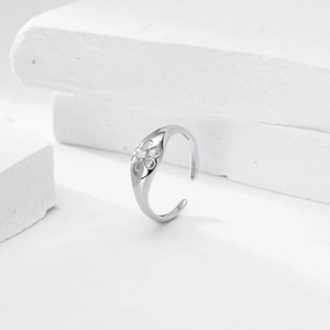 Macro shot of S925 sterling silver floral ring with sparkling zircon on stone background