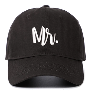 Close-up of 'Mr.' white 3D embroidery on a black cotton twill baseball cap with curved brim