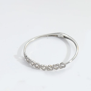 Close-up of silver heart-shaped bracelet featuring delicate sparkling zircon stone inlay