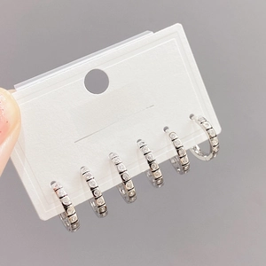 Detailed view of five silver-toned micro-paved zircon hoops on a display card