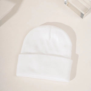 Close-up of a white ribbed knit beanie featuring fine stitching and a cuffed edge design