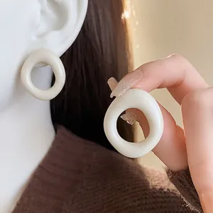 Modern minimalist hollow resin round stud earrings in creamy white finish for women