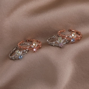 Detailed view of crown-shaped adjustable rings with filigree and colorful zircons