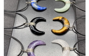 Detailed overhead view of wire-wrapped crescent moon natural crystal necklaces set