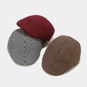 Flat caps in various houndstooth patterns showing red, black and brown tweed textures
