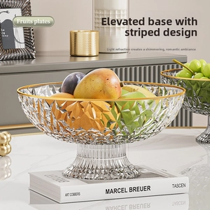 Detailed view of tall pedestal fruit plate with transparent glass and gold rim edge