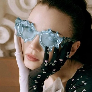 Detailed view of futuristic irregular sunglasses with blue ice-crack patterns on a model