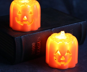 Makroansicht von warm leuchtenden Halloween-Kürbis-LED-Lichtern auf einem alten Buch