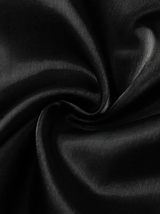 Macro shot of black satin fabric texture with elegant folds and reflective surface gloss