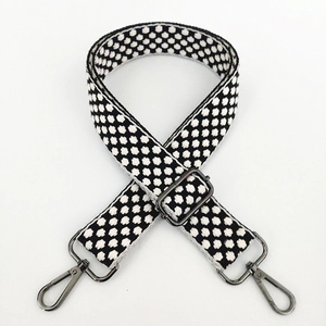 Close-up of black and white polka dot guitar strap with gunmetal swivel hooks