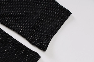 Vue macro d'un tricot noir avec paillettes argentées et détails de couture fins