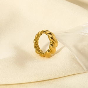Detailed close-up of 18K gold-plated croissant ring with high-polish texture on fabric
