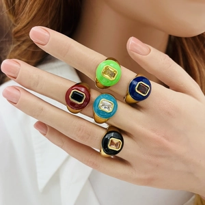 Detail of five colorful enamel heart rings with rectangle gemstones on a model hand