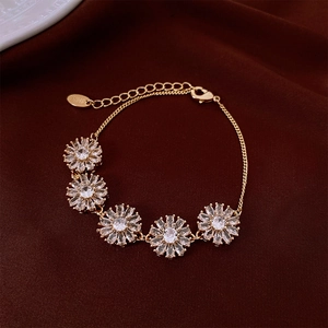 Détail macro du bracelet fleurs plaqué or 18K avec zircons et breloque SHINE