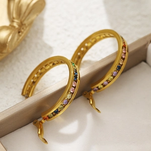 Detailed shot of gold hoop earrings with multi-colored cubic zirconia on a luxury tray