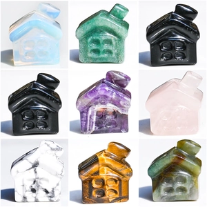 Set of nine hand-carved natural crystal mini houses in various gemstones on a white background