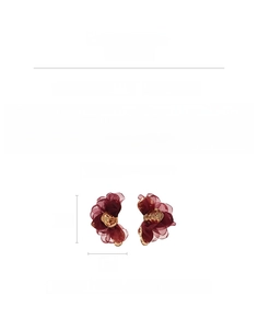 Detail view of large burgundy chiffon flower earring with gold metallic center and specs