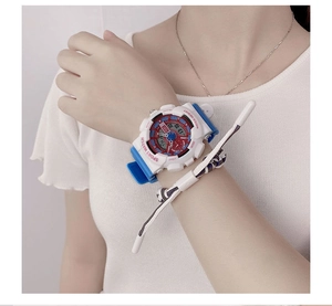 Detailed view of the digital sports watch on wrist featuring blue and red accent design
