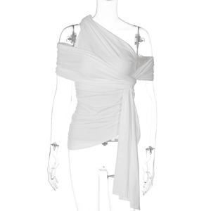 Détail du débardeur blanc asymétrique avec ruban décoratif à la taille et coupe ajustée slim