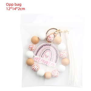 Close-up of Mama rainbow charm keychain with leopard beads and white tassel in OPP bag