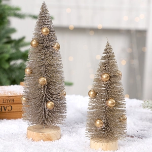 Miniature pine needle Christmas trees with gold ornaments and wooden bases on snow