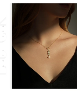 Macro detail of irregular gold pendant with white pearl on a delicate necklace chain