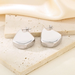 Boucles d'oreilles géométriques argentées polies sur travertin et tissu en soie