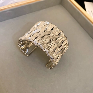 Detailed close-up of a silver braided twist bracelet with textured metal wire patterns