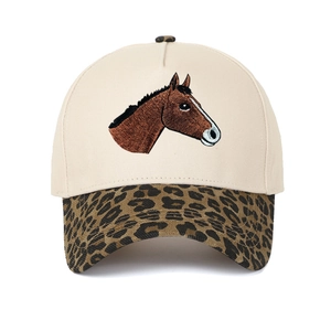Detail der beigen Baseballkappe mit Pferde-Stickerei und Schirm im Leopardenmuster