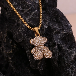 Detail of a 18K gold plated teddy bear pendant with crystals on a square box chain