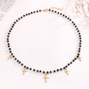 Detail view of black faceted bead necklace with gold cross charms and lobster clasp