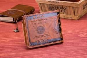 Detail of bifold brown leather wallet with dollar bill print on wooden table