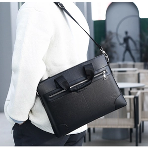 Black pebbled leather briefcase worn by model showing size and shoulder strap detail