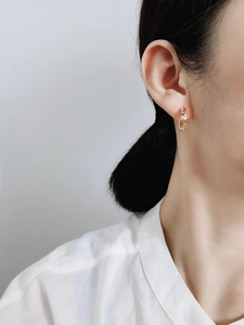 Close-up of rose gold hollow link chain hoop earring worn on female ear for detail