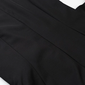 Detailed close-up of parallel stitching and smooth black fabric texture on the dress