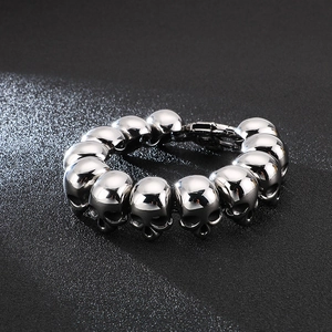 Close-up of polished stainless steel skull link bracelet with gothic aesthetic