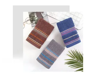 Detailed view of three-color striped cotton towels set with soft plush texture in lifestyle decor