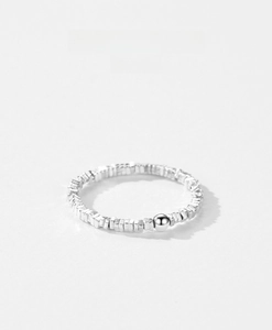 Detailed shot of S925 sterling silver ring featuring irregular crushed texture and central bead