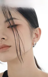 Macro close-up of S925 sterling silver hoop earrings with irregular wrinkled texture on ear