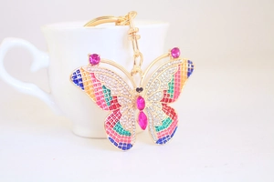 Detailed close-up of a golden butterfly keychain with colorful gems and rhinestones