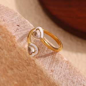 Detail of 18K gold heart ring with white enamel edges and sparkling heart-shaped zircon