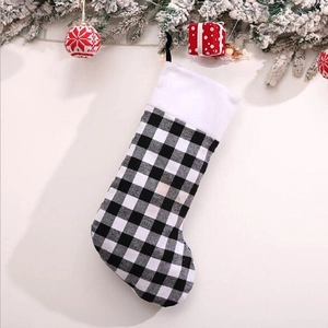 Classic black and white buffalo plaid Christmas stocking with white plush trim and festive decor