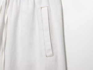 Détail du pantalon de jogging en jean blanc avec cordon et coutures doubles aux poches