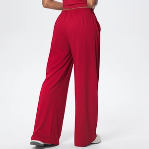 Detail view of red wide-leg lounge pants with elastic waistband and high drape fabric