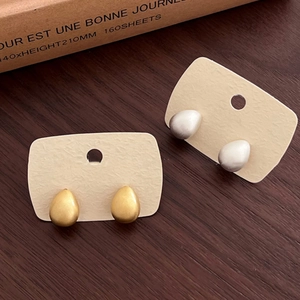 18k gold and silver plated metal teardrop earrings set on a minimalist display card