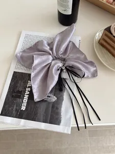 Chouchou en satin lavande avec nœud, perles et longs rubans noirs élégants