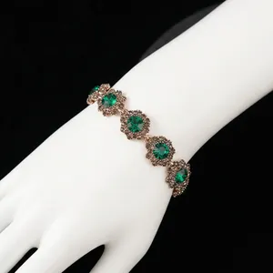 Vintage rose gold floral bracelet with green emerald crystals and dark grey diamonds
